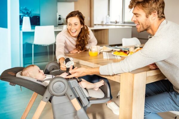 widescreen_retina_portrait-mc2713_2019_maxicosi_high_chair_minla_lifestyle_spring_momanddadplayingbabylayflat_landscape_rgb_2